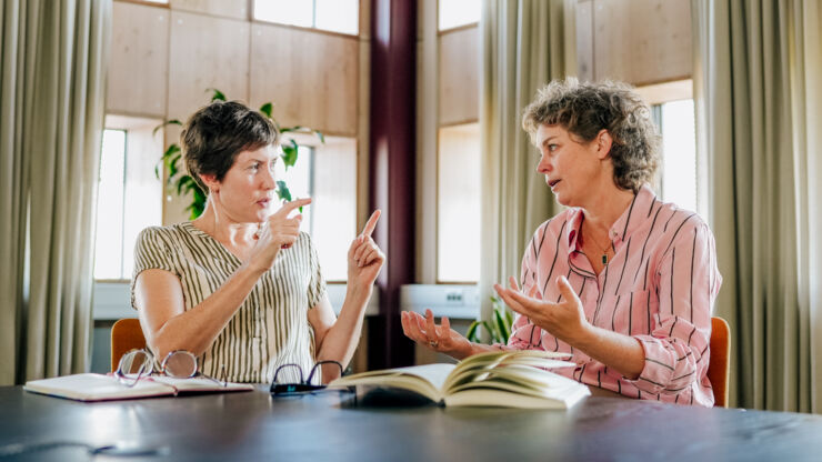 Two women at a table talking.