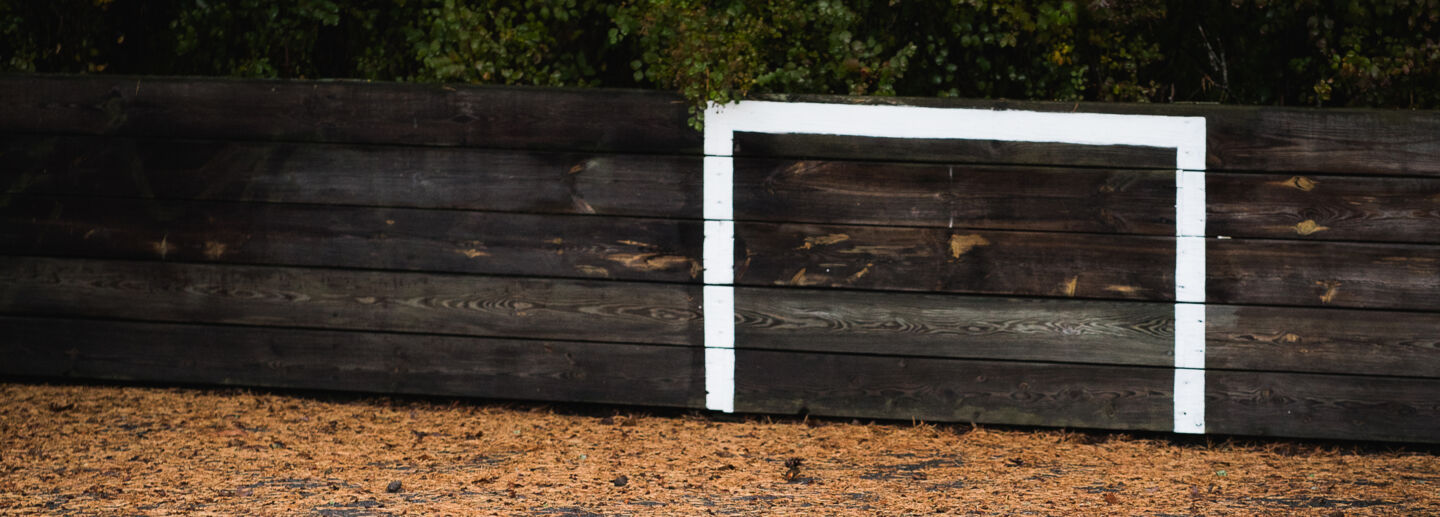 A wooden plank with a football goal drawn on it.