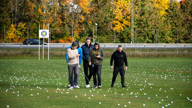 Studenter och en tekniker står ute på driving rangen på Linköpings golfklubb.