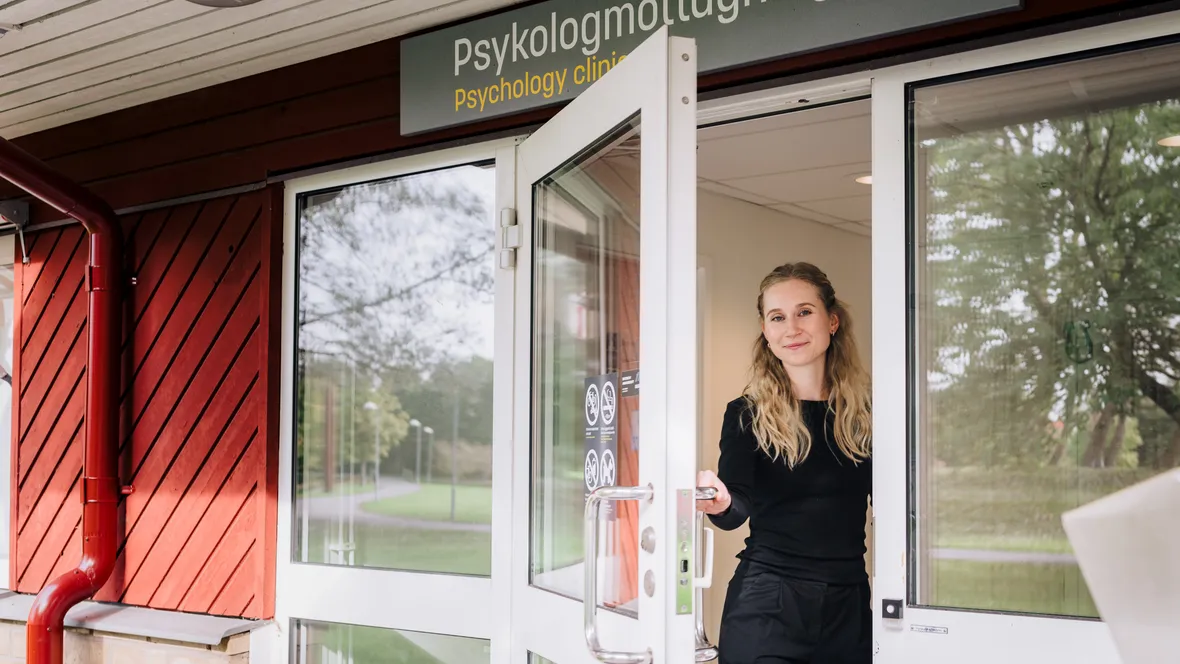 Ung kvinna öppnar en dörr