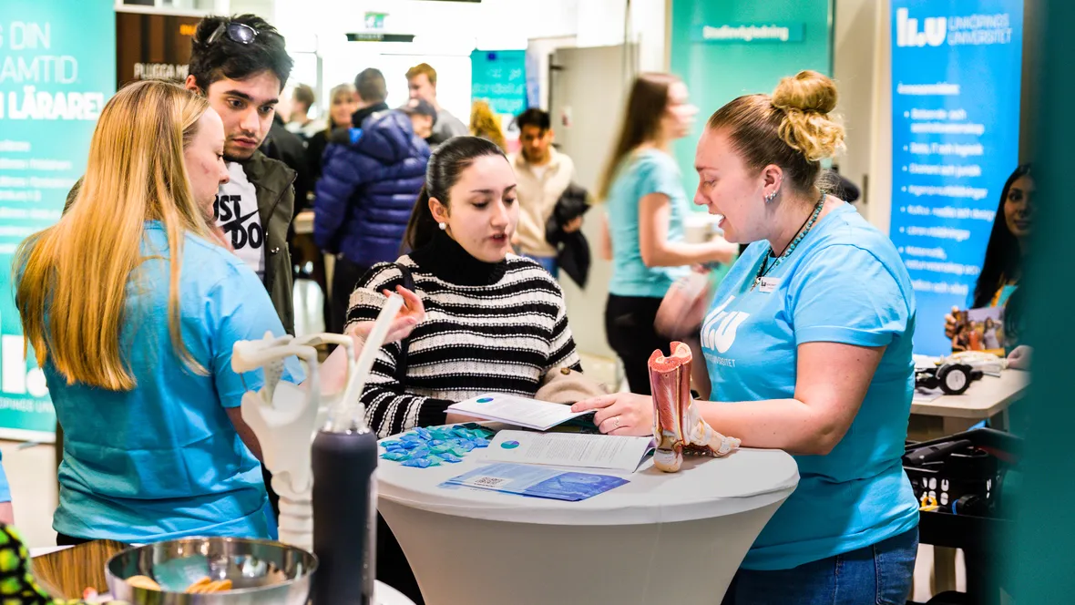 Kvinnlig LiU-student samtalar med besökare på mässa