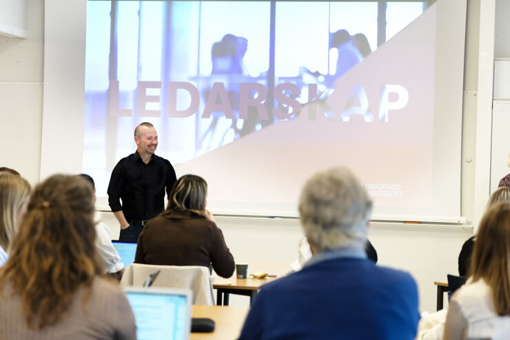 Forskare föreläser framför grupp av yrkesverksamma.