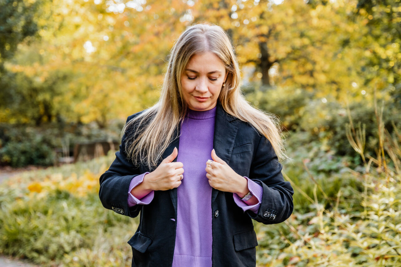 Rinata Kazak looking down at her jacket.