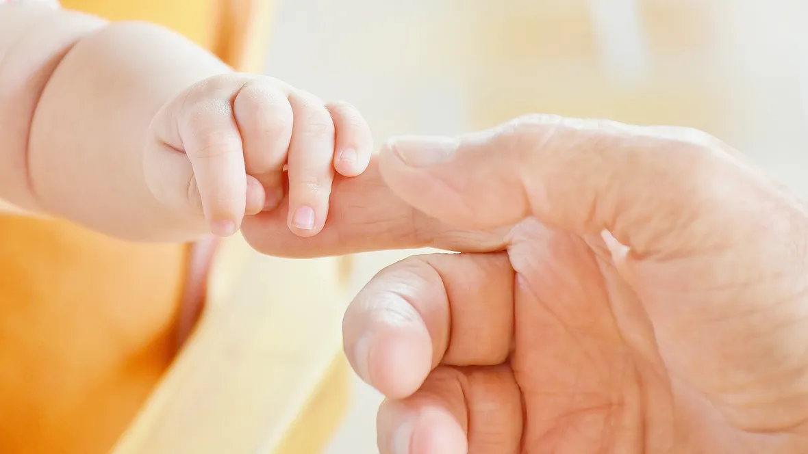 Baby hand and adult hand.