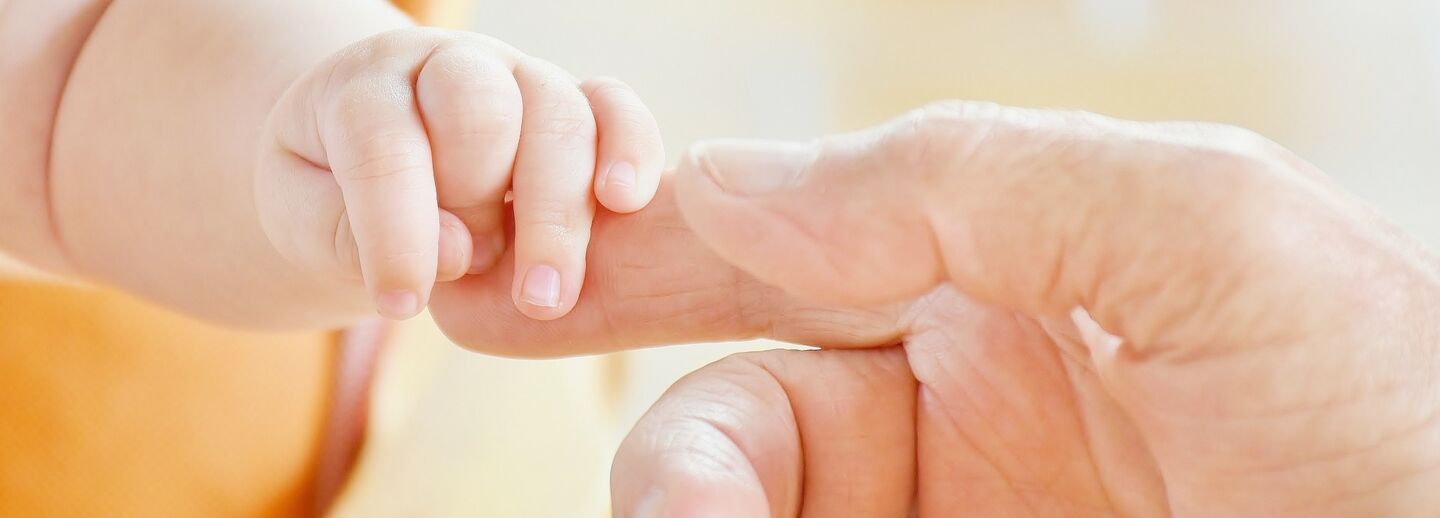 Baby hand and adult hand.