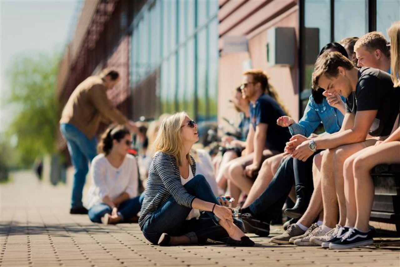 A group of students sitting outside the A building