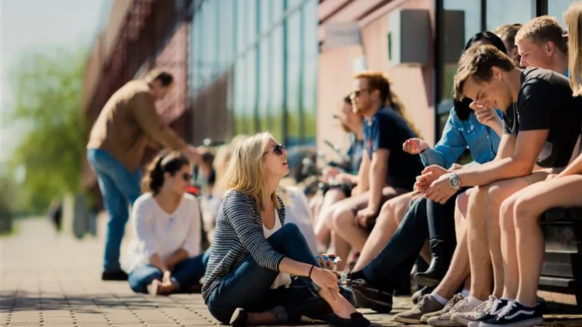 A group of students sitting outside the A building