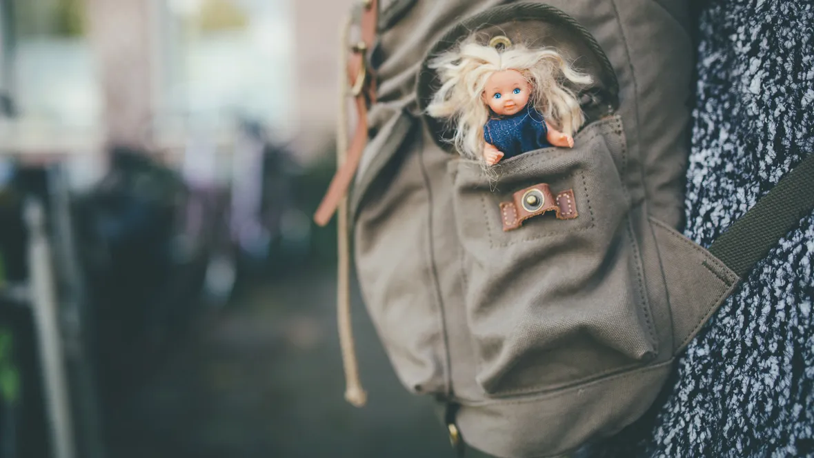A doll in a backpack