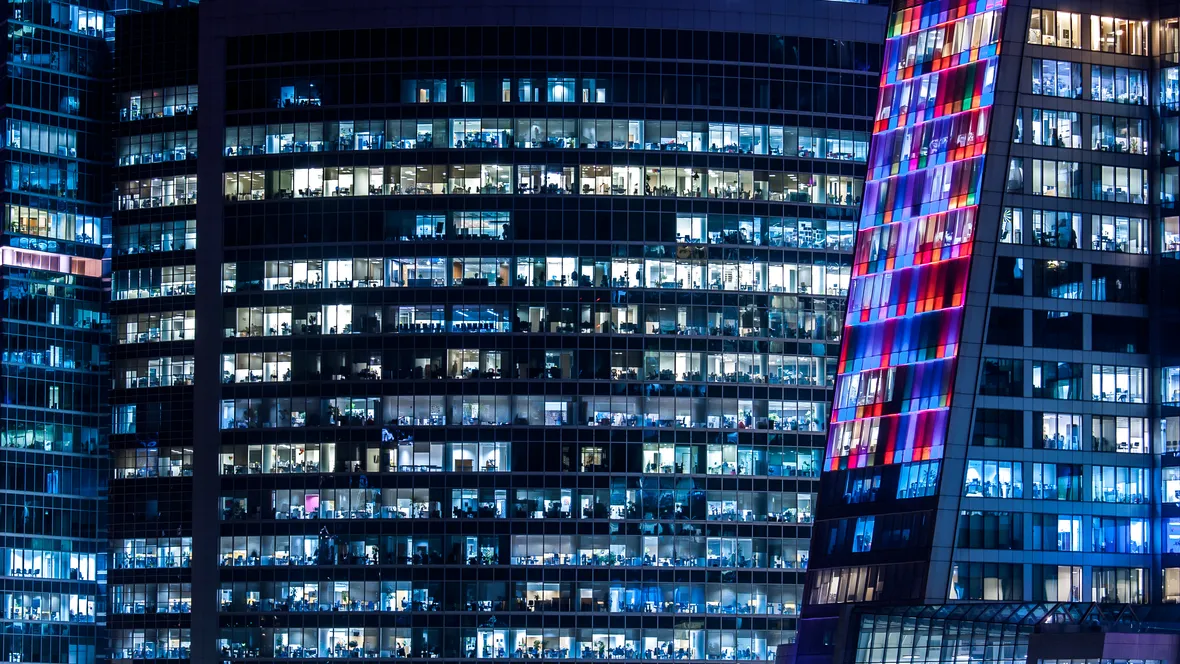 parts of office buildings in the dark. Lights are on in almost every office