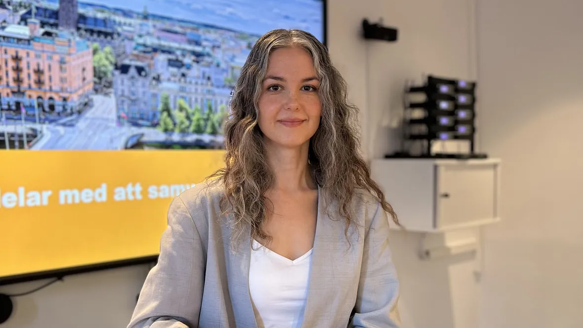 Ung långhårig kvinna står vid ett bord