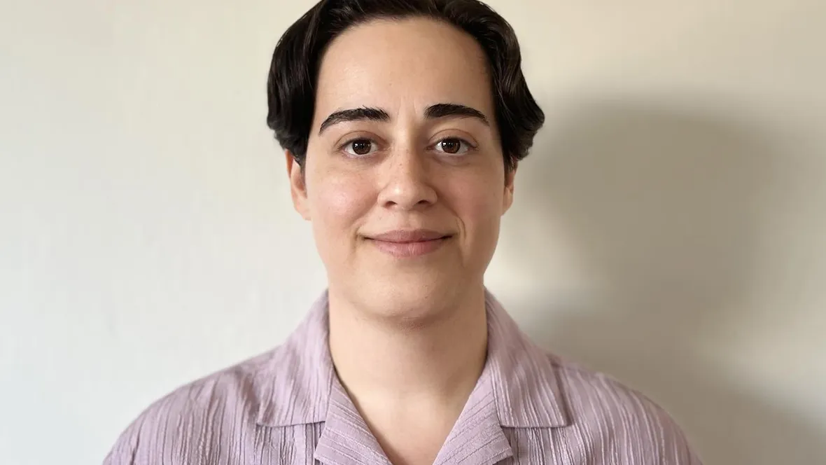 Porträttbild av kvinna med kort mörkt hår och ljuslila skjorta