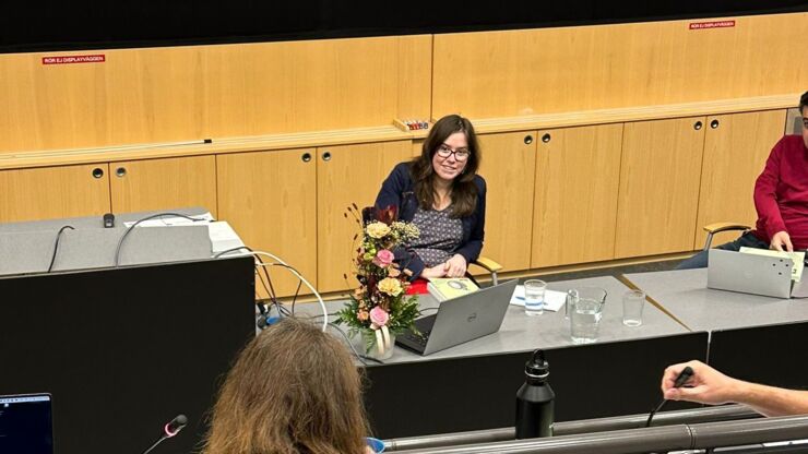 Woman sitting at desk with flowers and laptop during dissertation