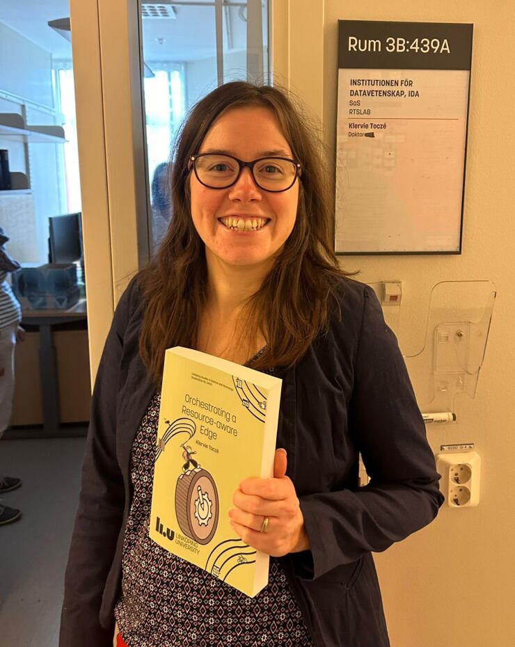 Smiling woman holding her thesis