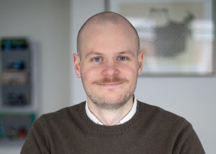 Young happy man with a moustache and a brown sweater