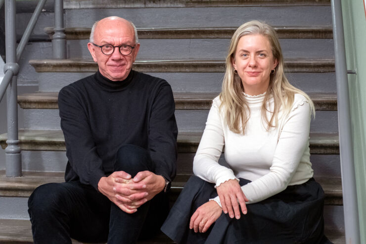 Peter Hedström and Maria Brandén sits next to each other in a staircase. 