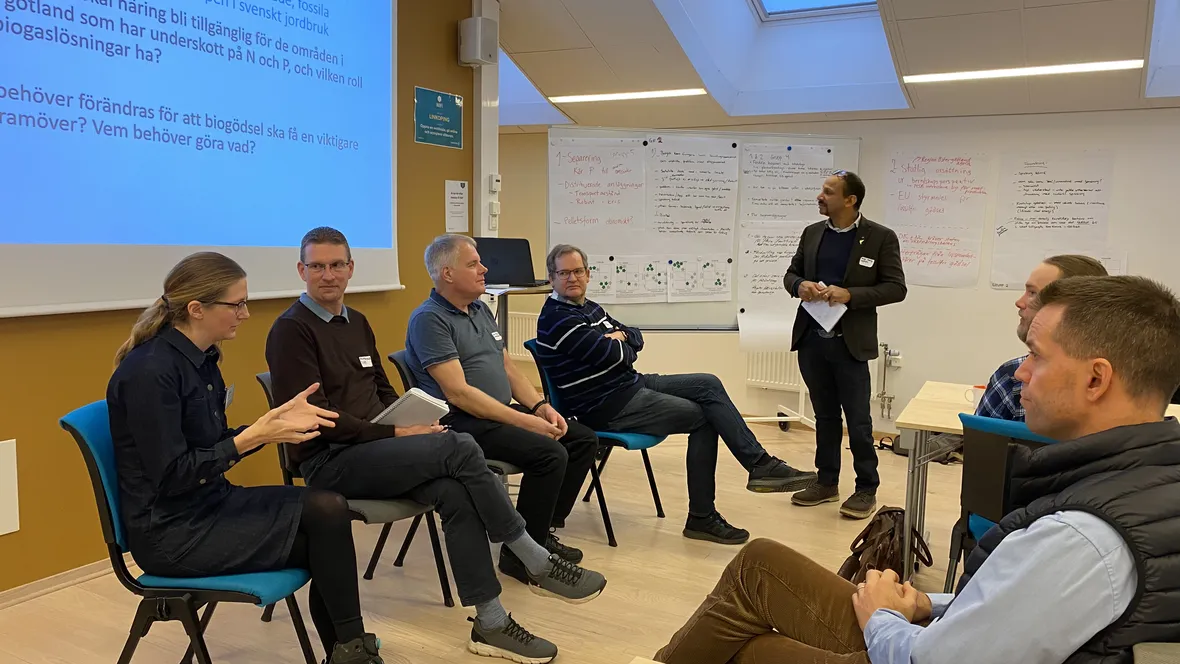 En grupp människor sitter i cirkel och samtalar.