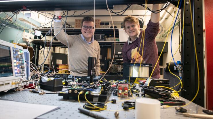 Two persons in a room full och wires and optical instruments.