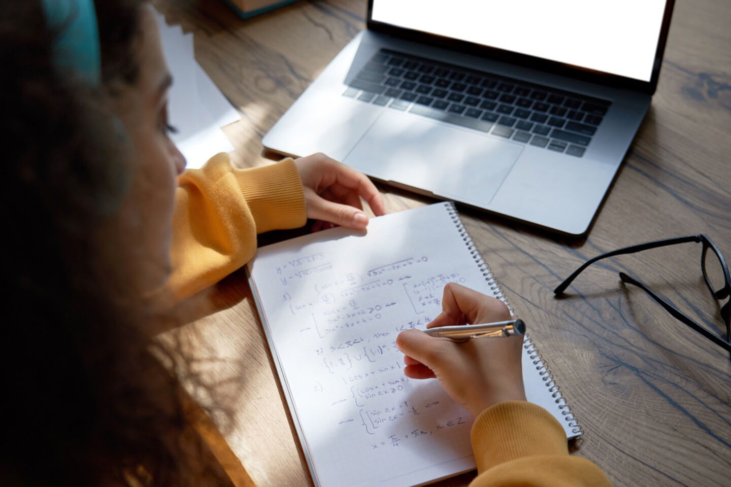 Young person calculating math problem in front of computer