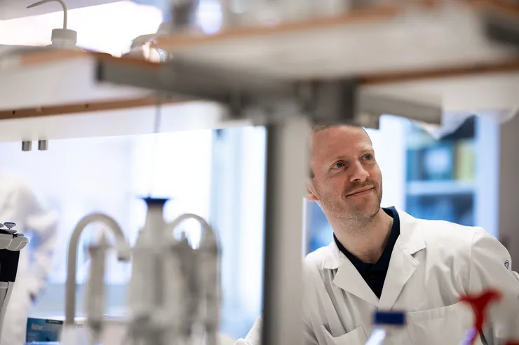 Young man wearing a white lab coat in a laboratory.